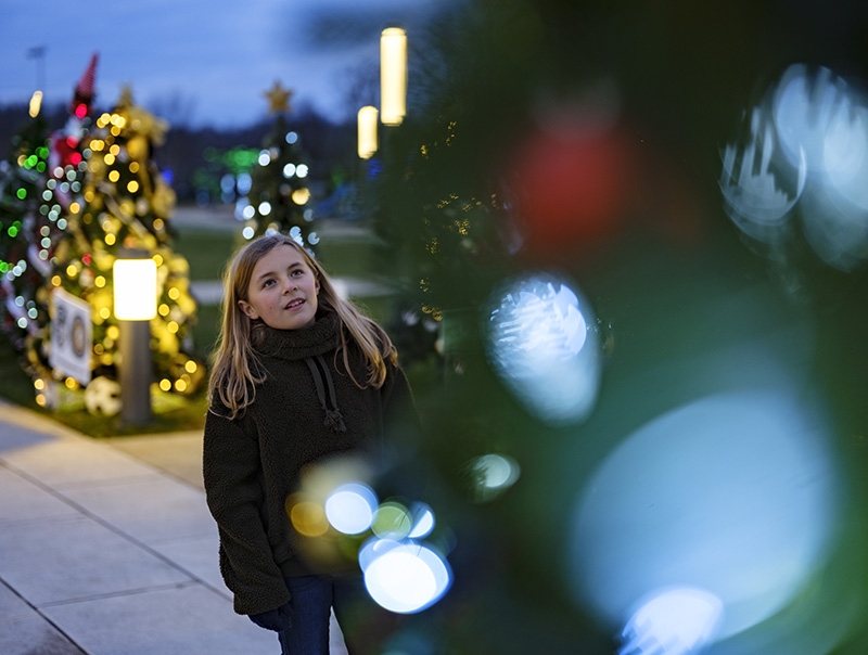 girl staring at Christmas tree